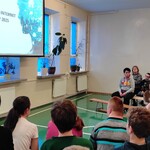 Nauczyciel mówi do uczniów siedzących na ławeczkach