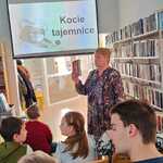 Pani bibliotekarka omawia slajd wyświetlany na ekranie.