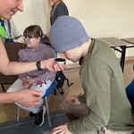 Nauczycielka daje do powąchania uczniowi pudełko z czosnkiem