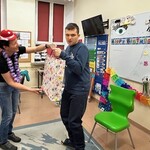 Uczeń bierze prezent z rąk nauczyciela