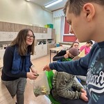 Uczeń częstuje cukierkami nauczycielkę