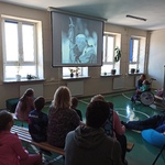 Uczniowie oglądają film wyświetlany na ekranie.