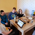 Grupa uczniów siedzi przy stole,