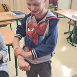 Uczeń w trakcie wykonywania opatrunki na ręce.