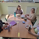 Uczennice siedzą przy stoliku i jedzą drugie śniadanie.