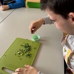 Uczeń wkłada szczypiorek do foremki na muffinki