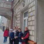 Grupa uczniów na tle zabytkowej kamienicy