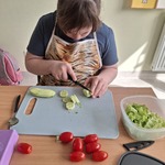 Uczennica kroi ogórek na plasterki