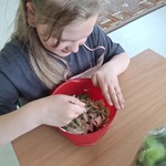 Uczennica miesza składniki sałatki w miseczce