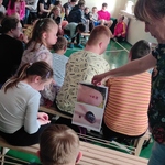 Uczniowie patrzą na zdjęcia pokazywane przez nauczycielkę