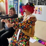 Klaun i nauczyciel wyciągają ręce