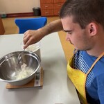 Uczeń sypie mąkę do miski