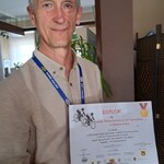 Nauczyciel trzyma otrzymany dyplom za udział