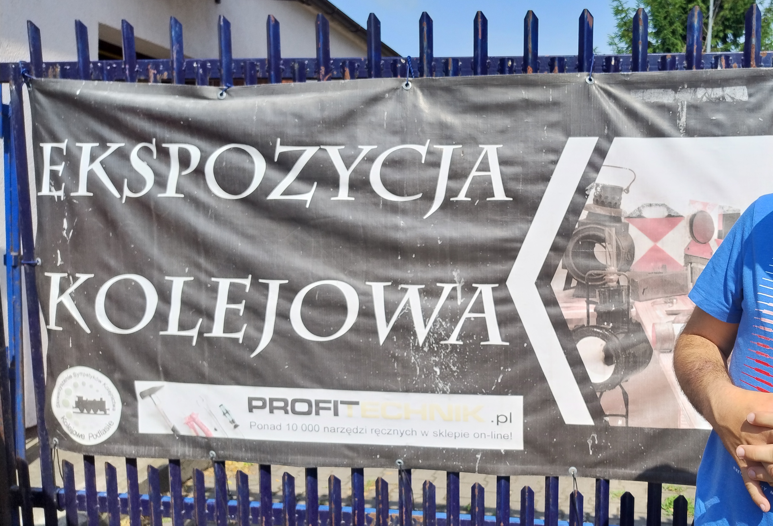 Uczeń stoi przy banerze z napisem "Ekspozycja Kolejowa"