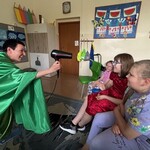 Nauczycieli śmieje się i trzyma suszarkę dmuchającą we włosy dzieci