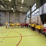 Uczestnicy zawodów stoją na sali gimnastycznej