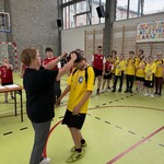 Nauczycielka  - organizatorka zawodów wręcza medal uczestnikowi