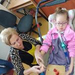 Nauczycielka z uczennicą kroją truskawki