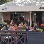Grupa uczniów siedzi w ogródku pizzerni
