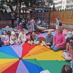 Uczniowie i nauczycielka  siedzą na chuście animacyjnej