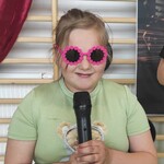 uczennica w różowych okularach i mikrofonem