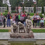 Uczestnicy półkolonii przy pomniku praczek w ogrodzie różanym