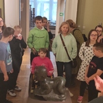 Uczestnicy półkolonii słuchają opowieści pani przewodnik