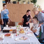 Nauczycielka i uczniowie wokół stołu urodzinowego
