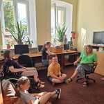 Nauczycielka i uczniowie siedzą w bibliotece