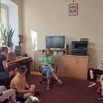 Grupa uczniów i nauczycielka siedzą w bibliotece