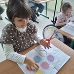 Uczennica wycina kolorowe kółka
