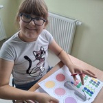 Uczennica wycina kolorowe kółka