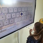Uczennica rozwiązuje zadanie przy tablicy interaktywnej