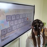 Uczennica rozwiązuje zadanie przy tablicy interaktywnej
