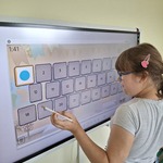 Uczennica rozwiązuje zadanie przy tablicy interaktywnej