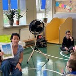 Nauczyciel trzyma ilustrację wiatraków elektrycznych