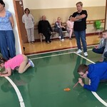 Uczniowie wdmuchują piórka do kartonu
