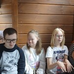 Trójka uczniów siedzi na ławce.