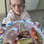Uczennica trzyma przed sobą talerz z kanapkaimi