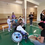 Uczennica na wózku wrzuca przedmiot do miski z wodą