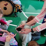 Nauczycielka pokazuje uczennicy pojemnik z ziemią