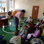 Nauczycielka pokazuje uczniom tablicę z symbolami
