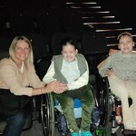 Nauczycielka i dwie uczennice siedzą na fotelach w sali kinowej