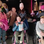 Grupa uczniów pozuje do zdjęcia w poczekalni kinowej