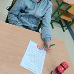 Uczeń siedzi przy stoliku i rozwiązuje kartę pracy