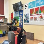 Nauczyciel dmucha balon, przed nim leżą cztery czarne kartki