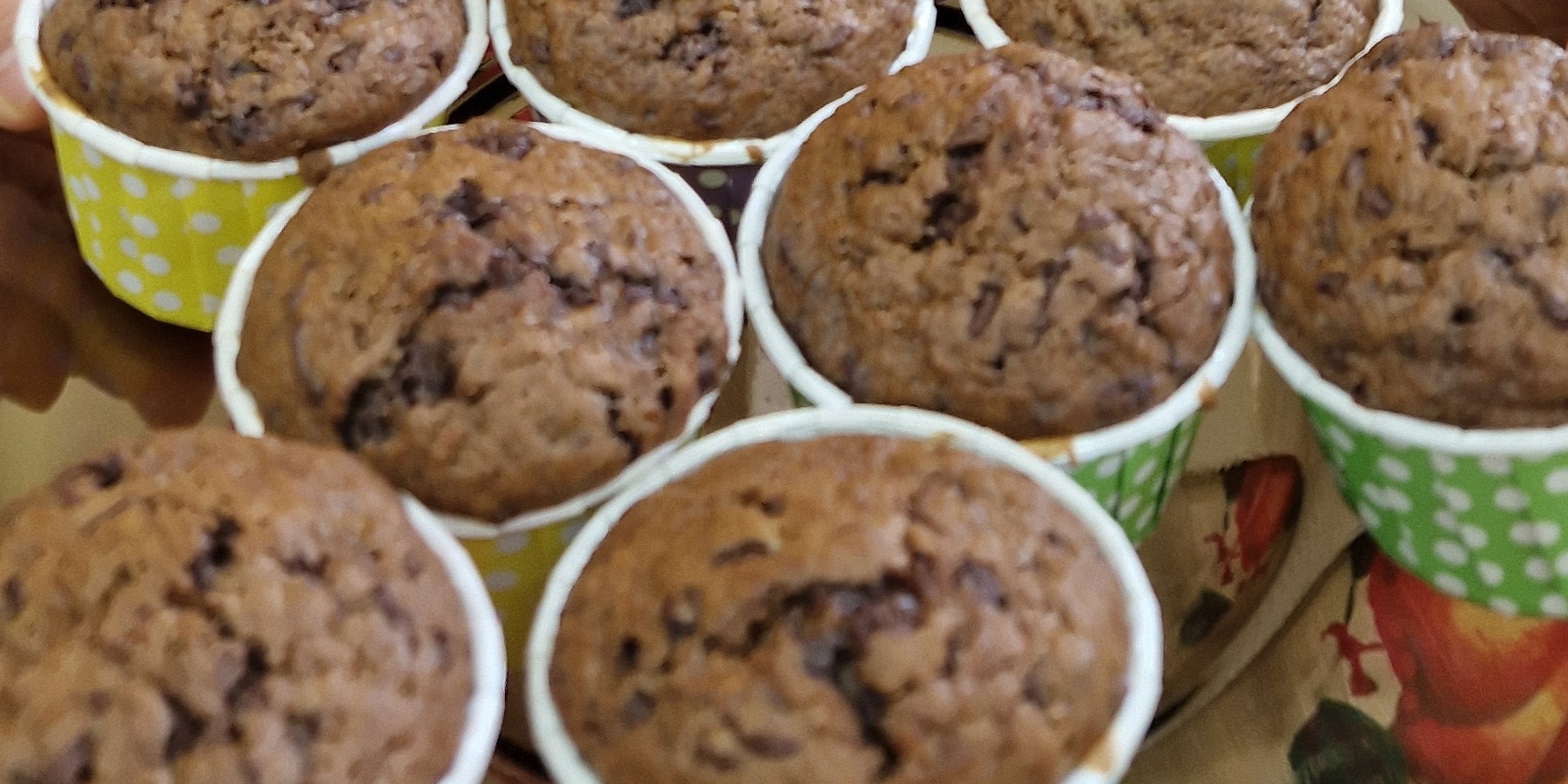 Uczennica trzyma przed sobą talerz babeczek.