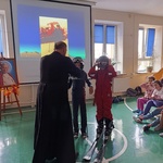 Ksiądz i dwójka uczniów w przebraniu narciarzy