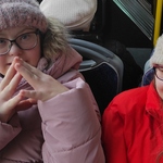 Dwie uczennice siedzą na siedzeniach w autobusie