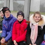 Uczniowie siedzą na przystanku autobusowym
